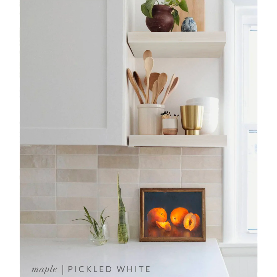maple floating shelves in a kitchen with the pickled white finish applied decorated with kitchen utensils, a plant, charcuterie board, and vases